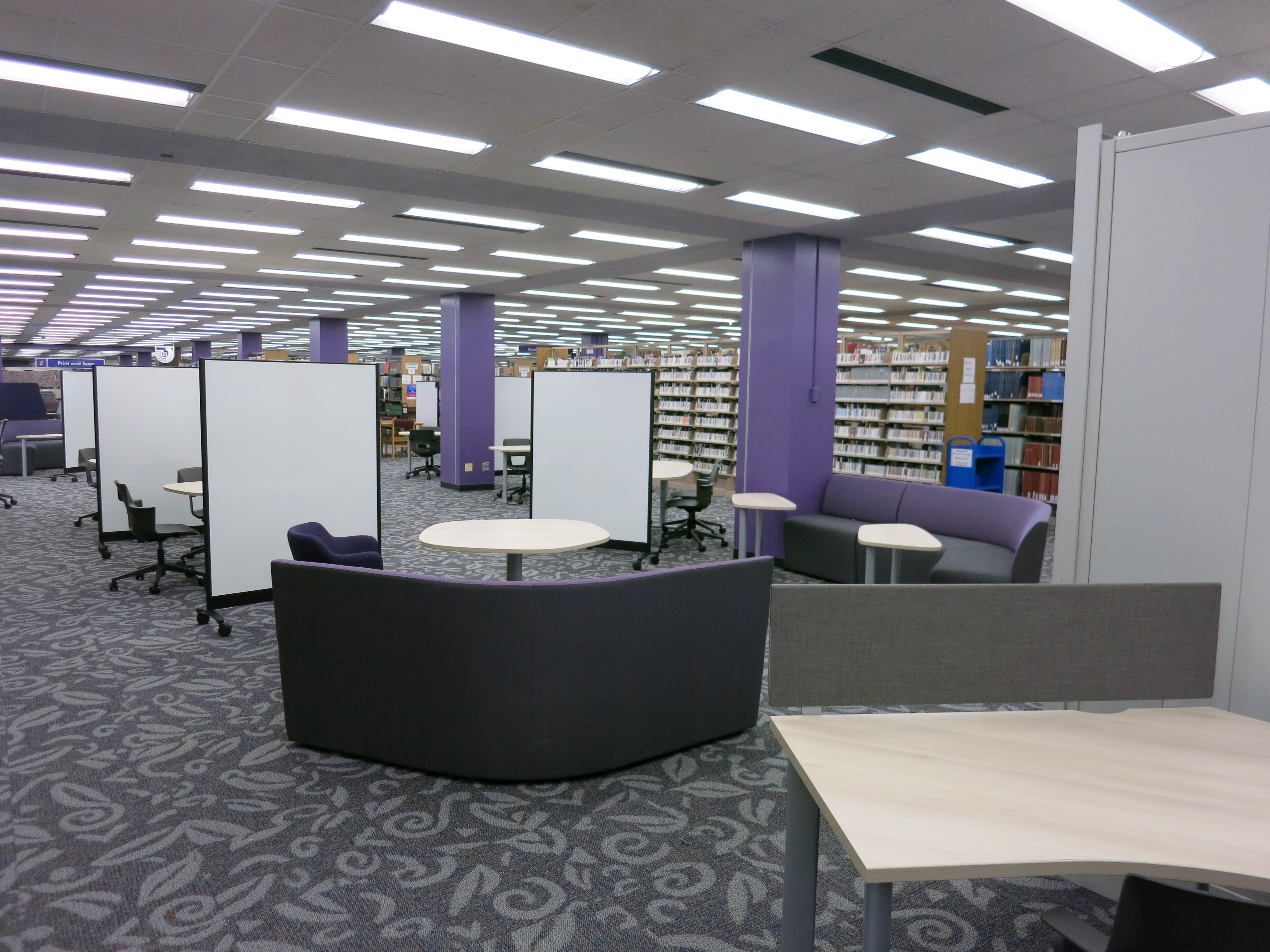 a room with tables and chairs in a library