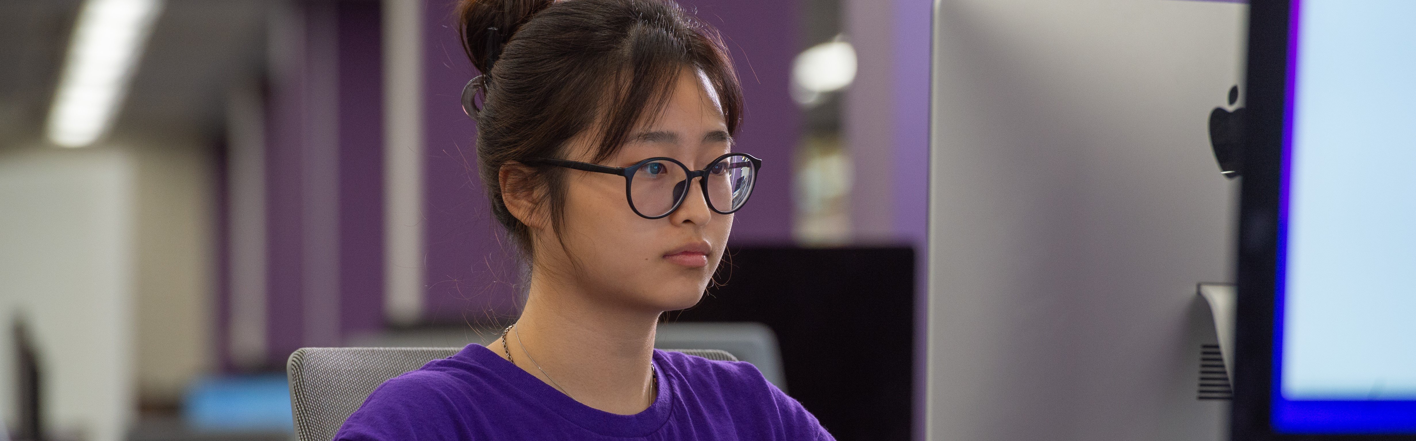 a person wearing glasses and a purple shirt